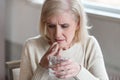 Senior unwell woman unsure about taking medicines at home Royalty Free Stock Photo