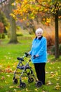 Senior lady with a walker in autumn park Royalty Free Stock Photo