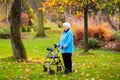 Senior lady with a walker in autumn park Royalty Free Stock Photo