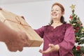 Senior couple celebrating the holidays at home, he gives her a Christmas gift Royalty Free Stock Photo