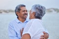 Senior, love and couple hug in nature at lake or beach on retirement holiday with a smile looking into eyes. Happy Royalty Free Stock Photo