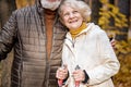 Senior lovely couple are walking together through the autumn woods, nordic walking Royalty Free Stock Photo