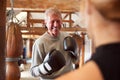 Senior Male Boxer Sparring With Younger Female Coach In Gym Using Training Gloves Royalty Free Stock Photo