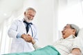 Senior male Doctor is talking with Asian male patient. Royalty Free Stock Photo