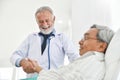 Senior male Doctor is talking with Asian male patient. Royalty Free Stock Photo