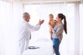 Senior doctor, mother and a baby boy in an office. Royalty Free Stock Photo