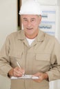 senior male electrician with clipboard by electrical fusebox Royalty Free Stock Photo