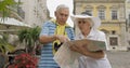 Senior male and female tourists standing with a map in hands looking for route Royalty Free Stock Photo