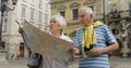 Senior male and female tourists standing with a map in hands looking for route Royalty Free Stock Photo