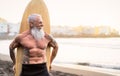 Senior male having fun surfing during sunset time - Fit retired man training with surfboard on the beach Royalty Free Stock Photo