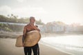 Senior male having fun surfing during sunset time - Fit retired man training with surfboard on the beach Royalty Free Stock Photo