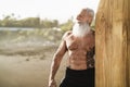 Senior male having fun surfing during sunset time - Fit retired man training with surfboard on the beach Royalty Free Stock Photo