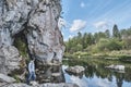 Senior male hiker standing on stony bank of river near rock. Summer nature landscape Royalty Free Stock Photo