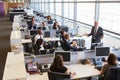 Senior male manager addressing workers in open plan office Royalty Free Stock Photo