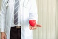 Senior male medicine doctor holding heart on abstract background., Close-up portrait of professional doctor giving red heart toy Royalty Free Stock Photo