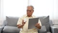 Senior male patient searching how to take medicine drug medicine using laptop Royalty Free Stock Photo