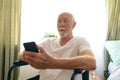 Senior male patient using mobile phone at retirement home Royalty Free Stock Photo