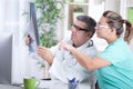 Senior male radiologist and female patient looking at x-ray Royalty Free Stock Photo