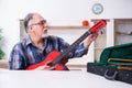 Senior male repairman repairing musical instruments at home Royalty Free Stock Photo