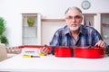 Senior male repairman repairing musical instruments at home Royalty Free Stock Photo