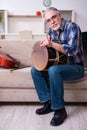 Senior male repairman repairing musical instruments at home Royalty Free Stock Photo