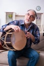 Senior male repairman repairing musical instruments at home Royalty Free Stock Photo