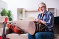 Senior male repairman repairing musical instruments at home Royalty Free Stock Photo