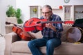 Senior male repairman repairing musical instruments at home Royalty Free Stock Photo