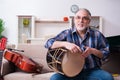 Senior male repairman repairing musical instruments at home Royalty Free Stock Photo