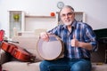 Senior male repairman repairing musical instruments at home Royalty Free Stock Photo