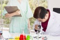 Senior male scientist looking through a microscope in a laboratory