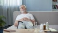 Senior male sleeping on sofa at home, relax after taking pills, medication Royalty Free Stock Photo