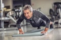 Senior male stays fit by doing pushups on a mat inside the fitness center Royalty Free Stock Photo