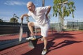 Senior male tennis player with back pain on court Royalty Free Stock Photo