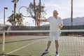 Senior male tennis player preparing to serve on court Royalty Free Stock Photo