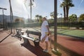 Senior male tennis player stretching leg on court Royalty Free Stock Photo