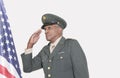 Senior male US military officer saluting American flag over gray background Royalty Free Stock Photo