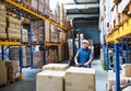 Senior male warehouse worker pulling a pallet truck. Royalty Free Stock Photo