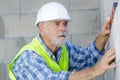 Senior male worker measuring wall Royalty Free Stock Photo