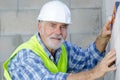 senior male worker measuring wall Royalty Free Stock Photo