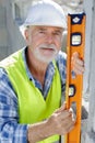 senior male worker measuring wall level Royalty Free Stock Photo