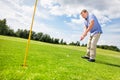 Senior man aiming to put a golf ball in the hole. Royalty Free Stock Photo
