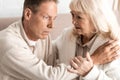 senior man with alzheimer disease sitting near worried wife. Royalty Free Stock Photo