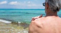 Senior man applying sun lotion on summer vacation Royalty Free Stock Photo