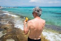 Senior man applying sun lotion on summer vacation Royalty Free Stock Photo
