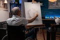 Senior man artist using wheelchair drawing original pencil drawing of still life vase feeling creative on easel