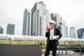 Senior man as professional engineer or technician use walkie talkie and stand near line of air vents on rooftop of construction