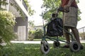 A senior man  as he strolls with his wheeling walker in garden Royalty Free Stock Photo