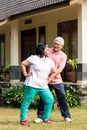 Senior man assisting his wife during warming up exercises outdoo