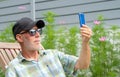 Senior man in a baseball cap portrait making selfie